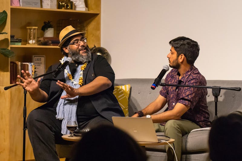 Abdul-Rehman Malik and curator, Asad Ali Jafri, sitting on a couch and talking in front of an audience.