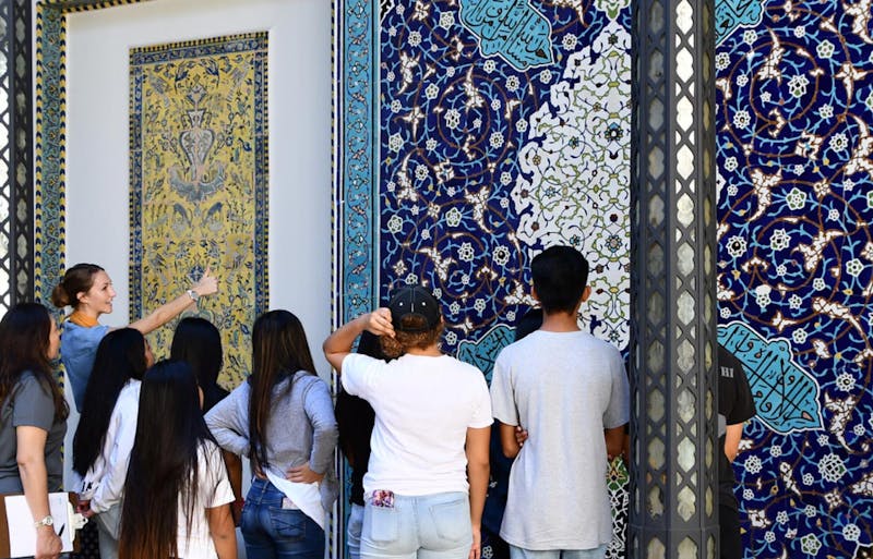 Photograph of Shangri La guide and students discuss the mosaic in the museum's central courtyard. 