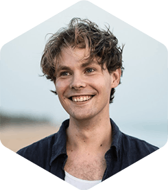 Picture of Aleksi. He has medium-length brown hair, and is smiling, looking away from the camera.