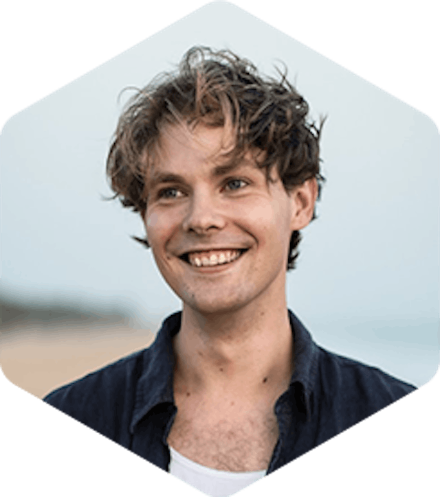 Picture of Aleksi. He has medium-length brown hair, and is smiling, looking away from the camera.