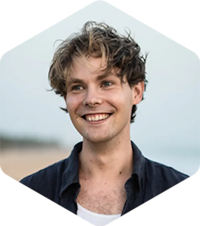 Picture of Aleksi. He has medium-length brown hair, and is smiling, looking away from the camera.