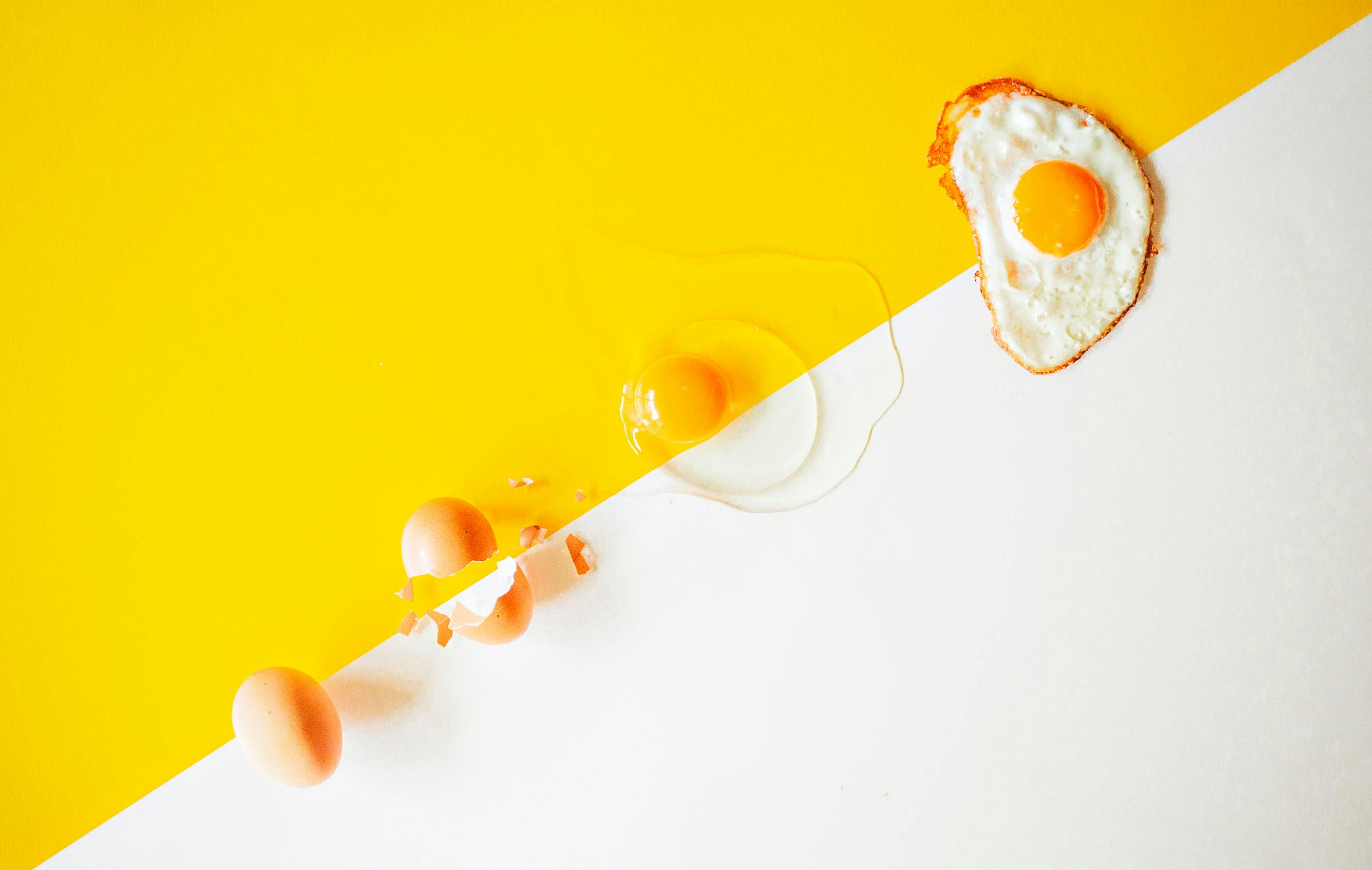 Four eggs in different stages from raw to fried sunny side up.