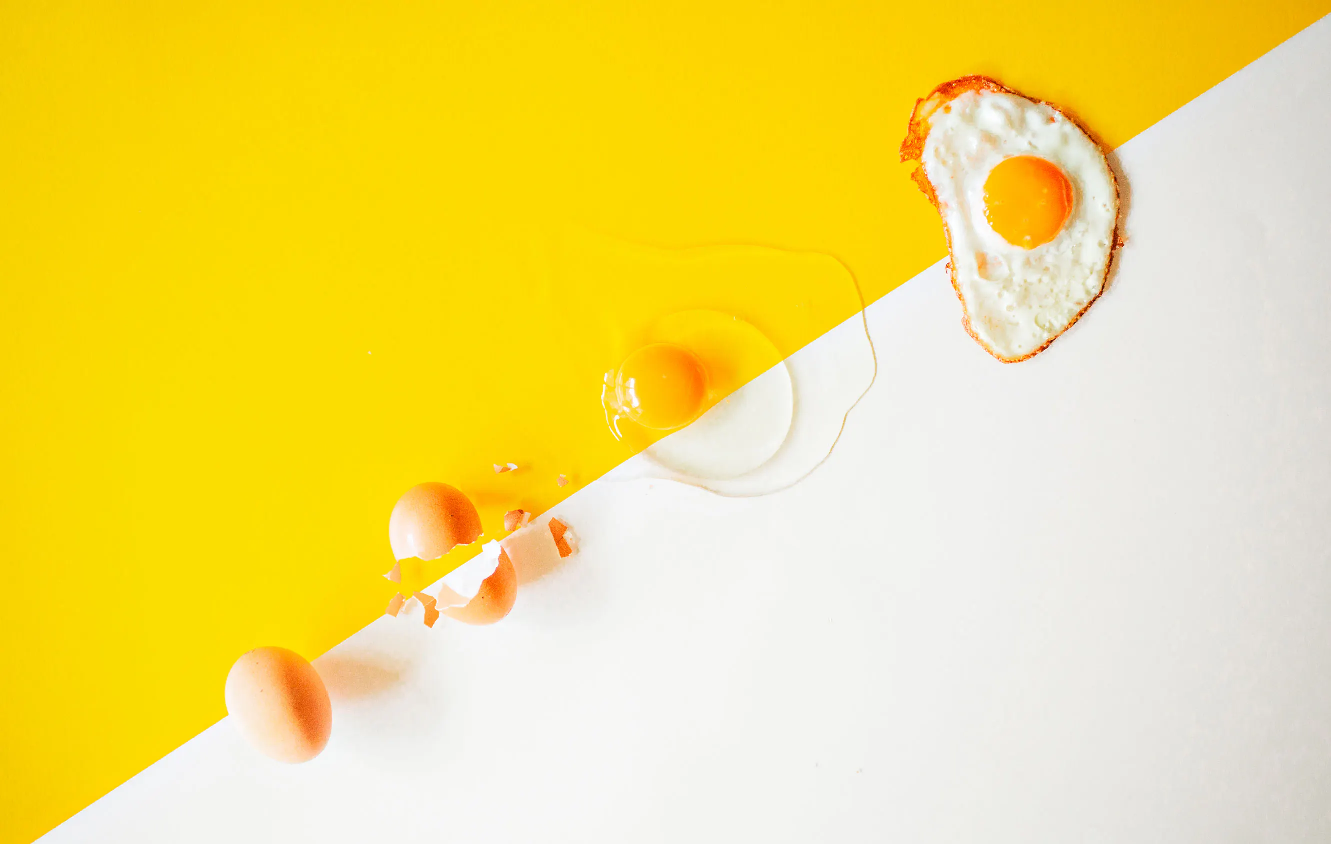 Four eggs in different stages from raw to fried sunny side up.