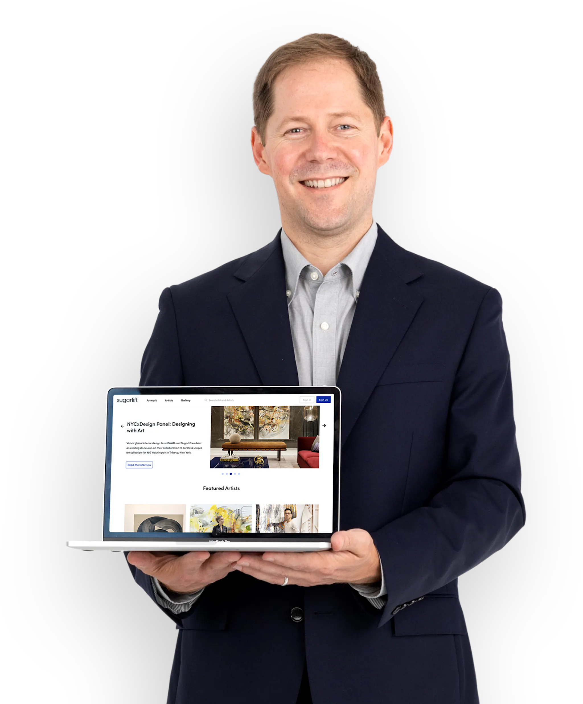 Sugarlift founder Wright smiling, holding a laptop facing the camera. The laptop is open on the Sugarlift landing page.