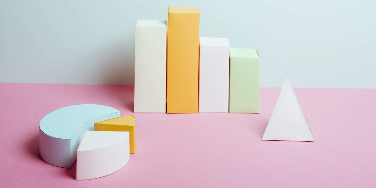 Pastel-colored 3-dimensional blocks arragned in the shapes of a pie chart and column chart.