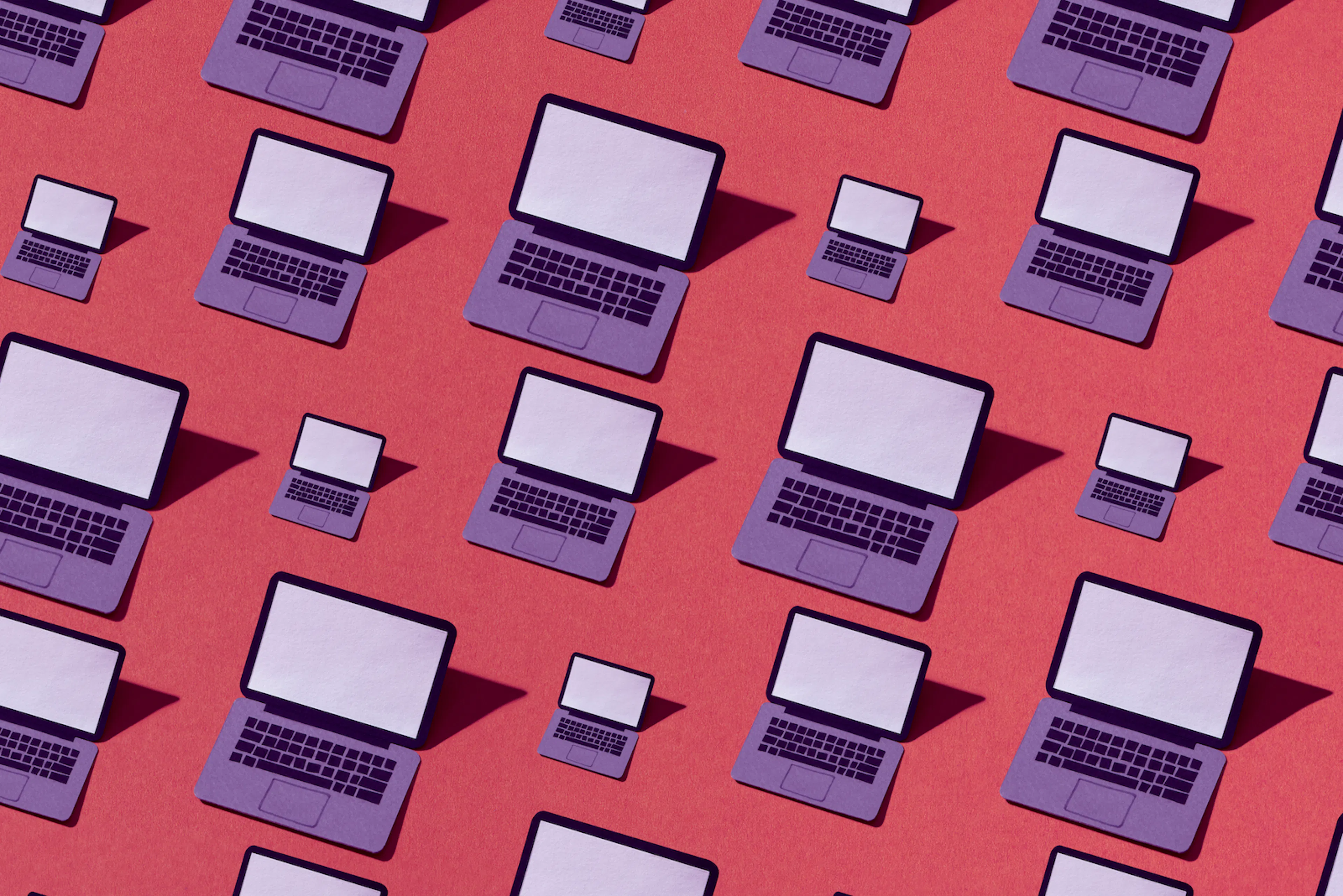 Many drawings of an open, purple laptop with a blank screen on a red background. The laptops are in different sizes and cast shadows to left.