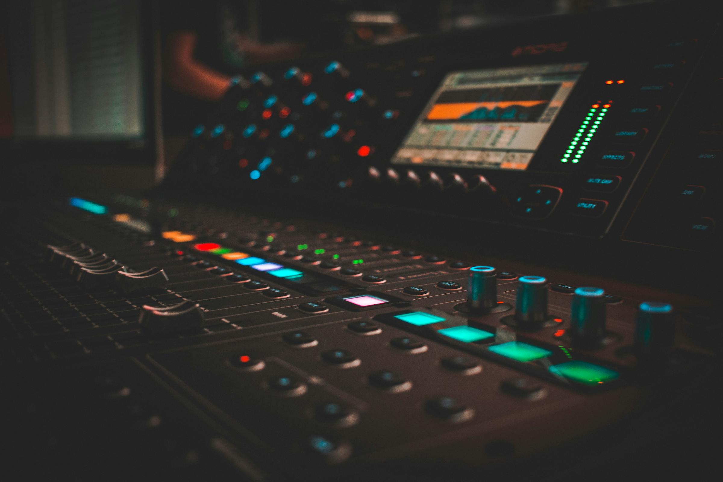 A close-up image of a mixing board with colorful lights