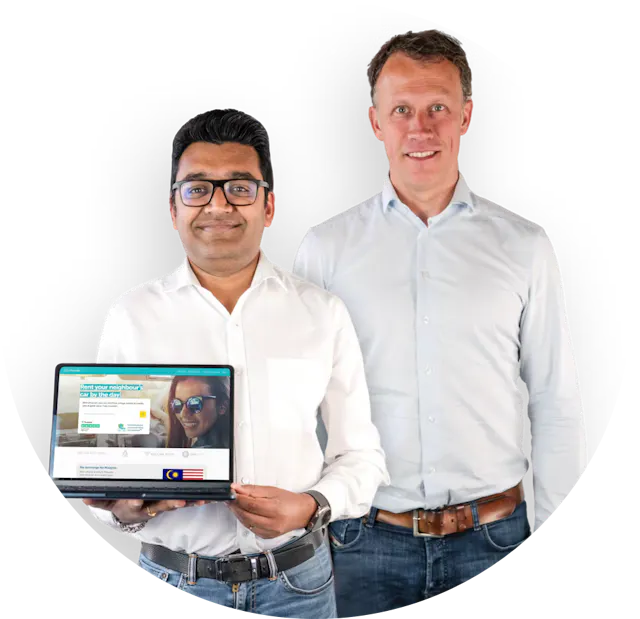 Drive lah founders Gaurav Singhal and Dirk-Jan der Horst. Both founders are smiling and wearing light button-down shirts and jeans. Gaurav is holding a laptop that's open to the Drive lah home page.