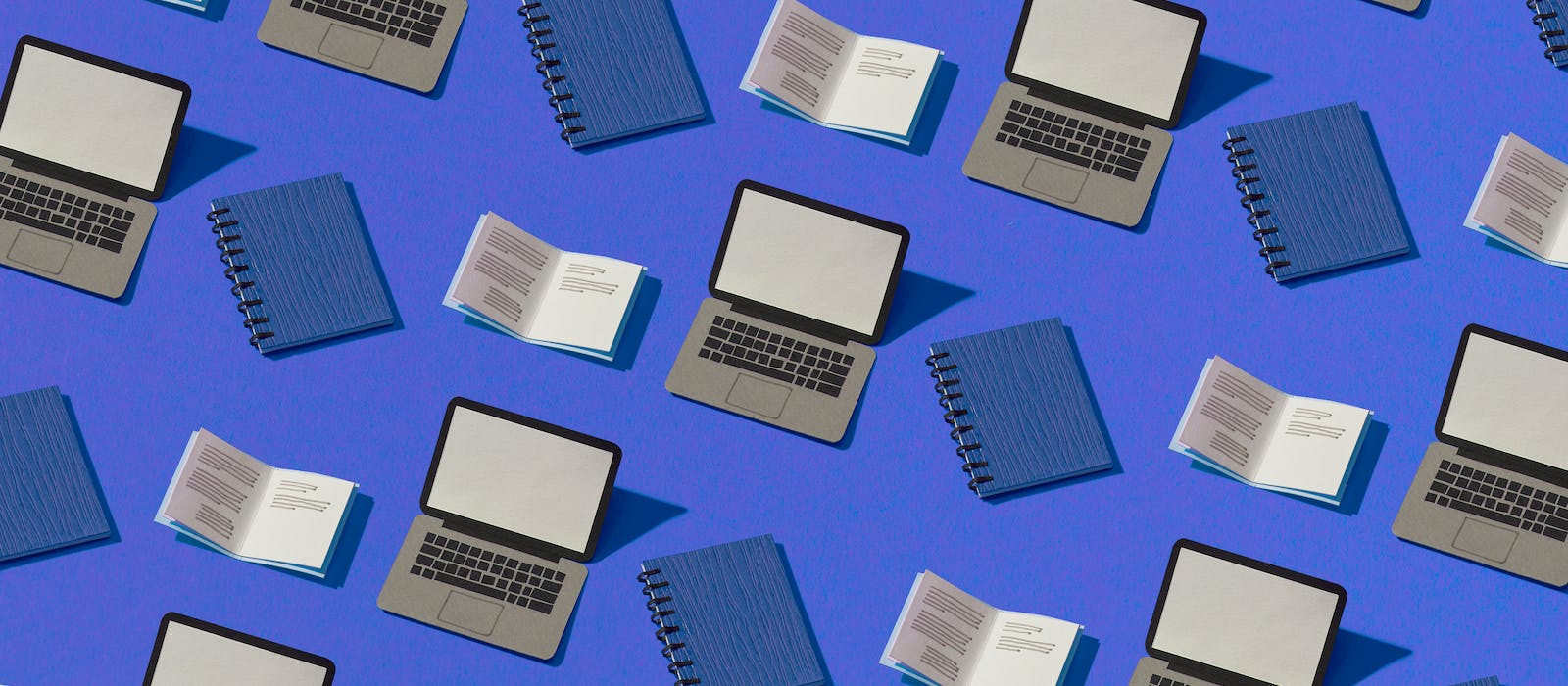 Multiple drawings of a open grey laptop, closed blue notebooks and open notebooks with black lines simulating text, interspersed on a blue background.