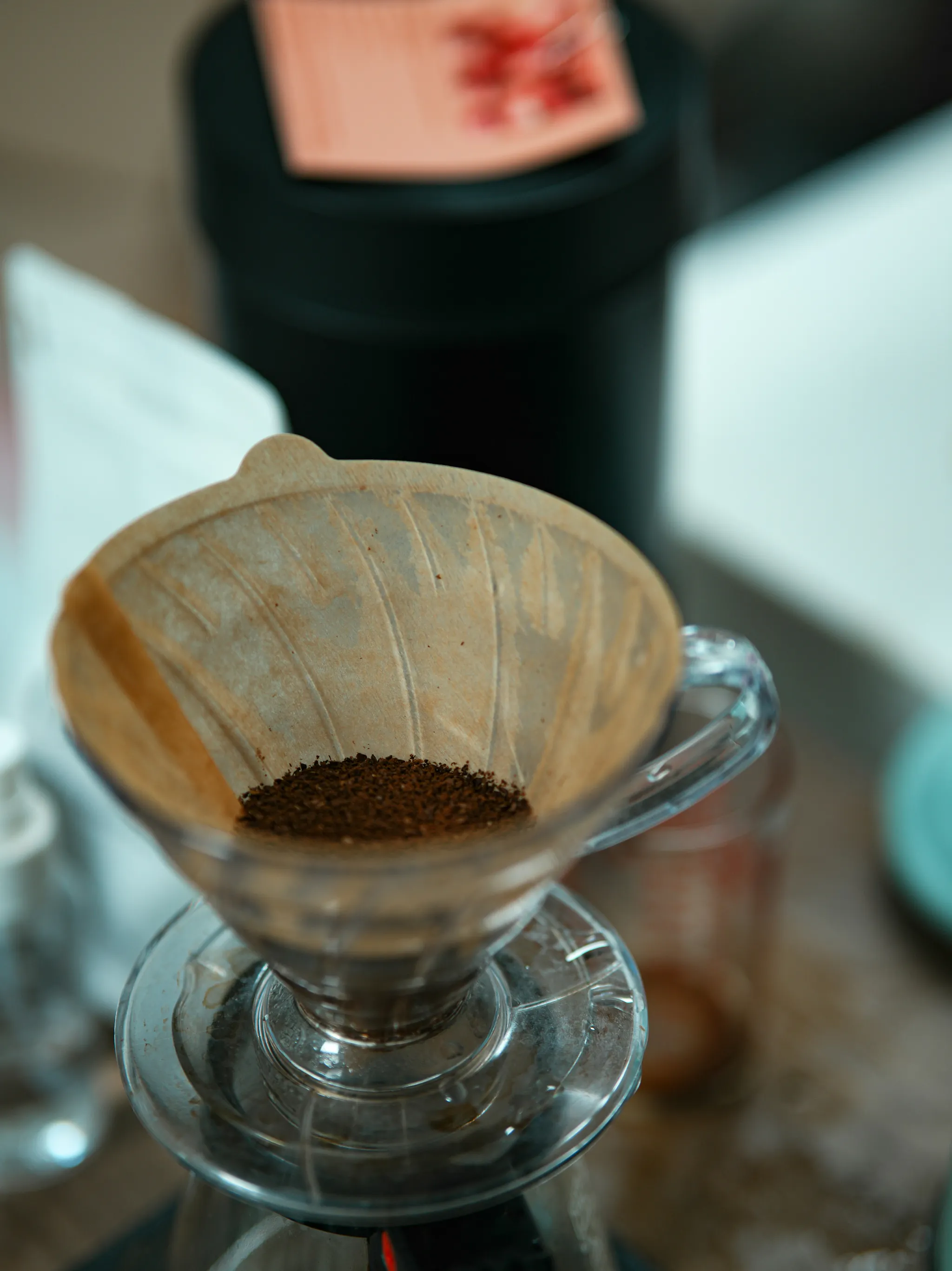A glass coffee filter on top of a glass coffee carafe