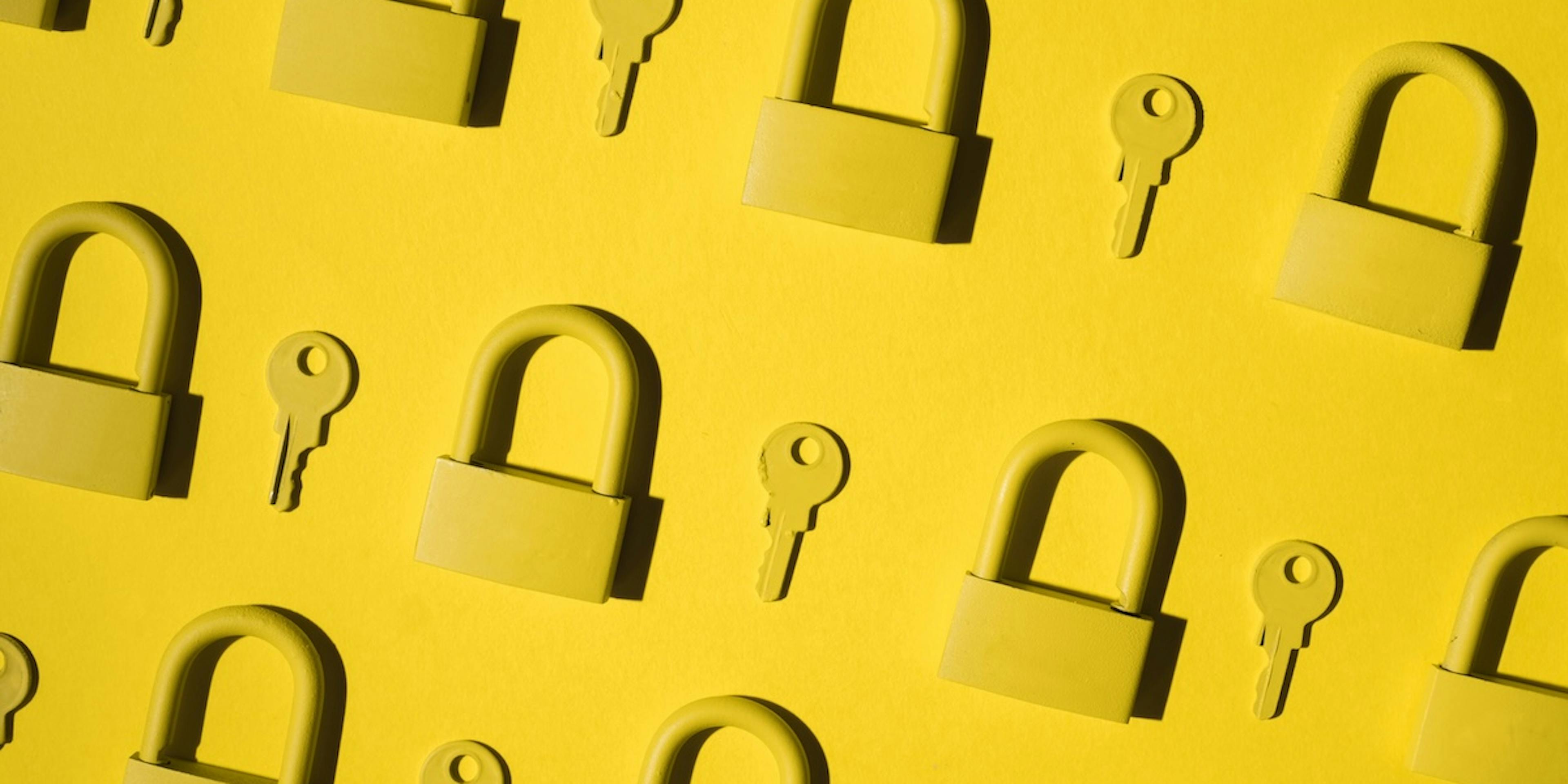Yellow locks and keys against a yellow background.