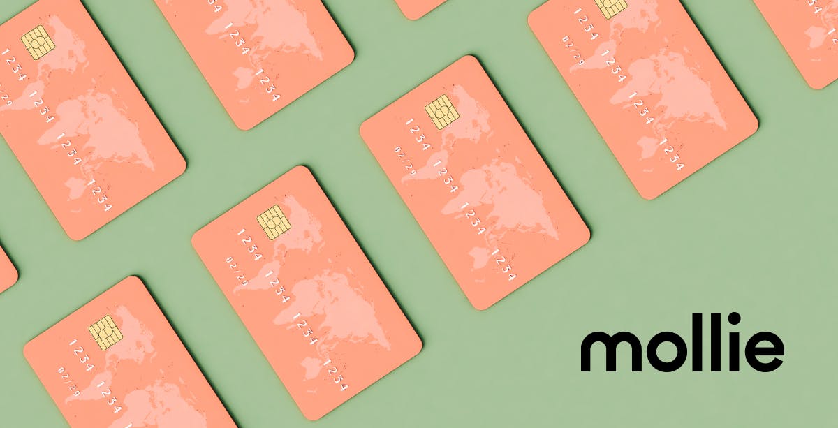 Sage green background with salmon pink credit cards with world map on the upper left corner, black Mollie logo in bottom right corner.
