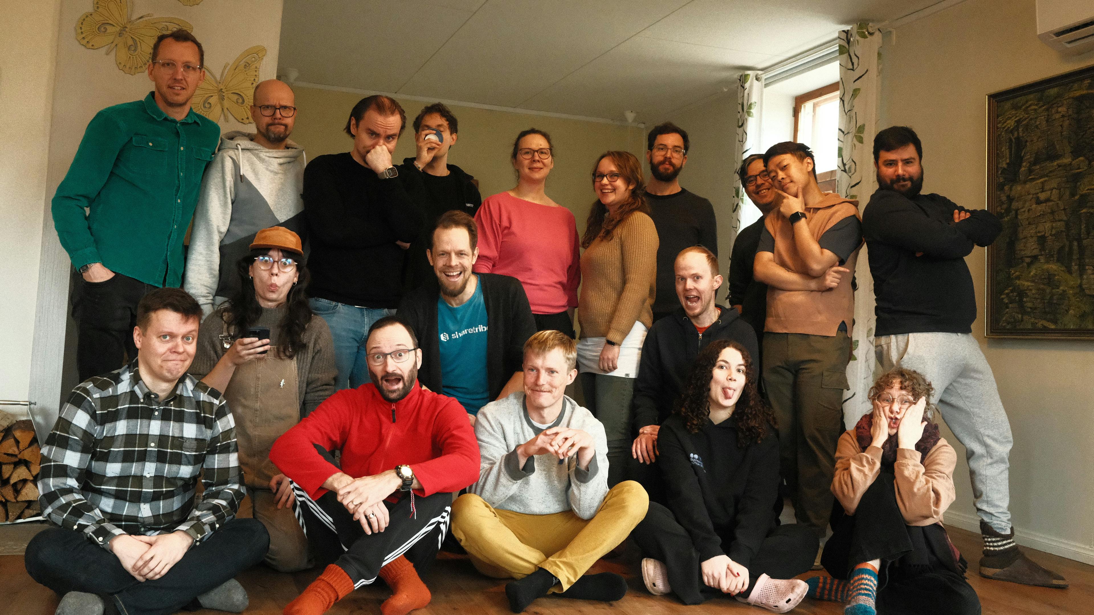 Sharetribe team posing together indoors, smiling and making playful expressions.