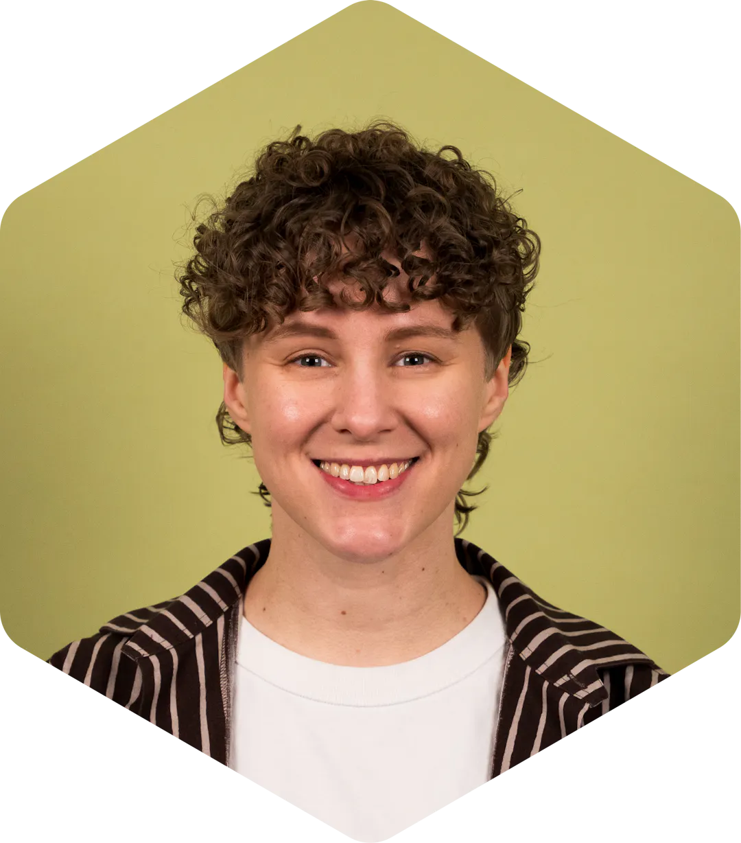 Katri smiling, wearing a striped shirt on a light green background.