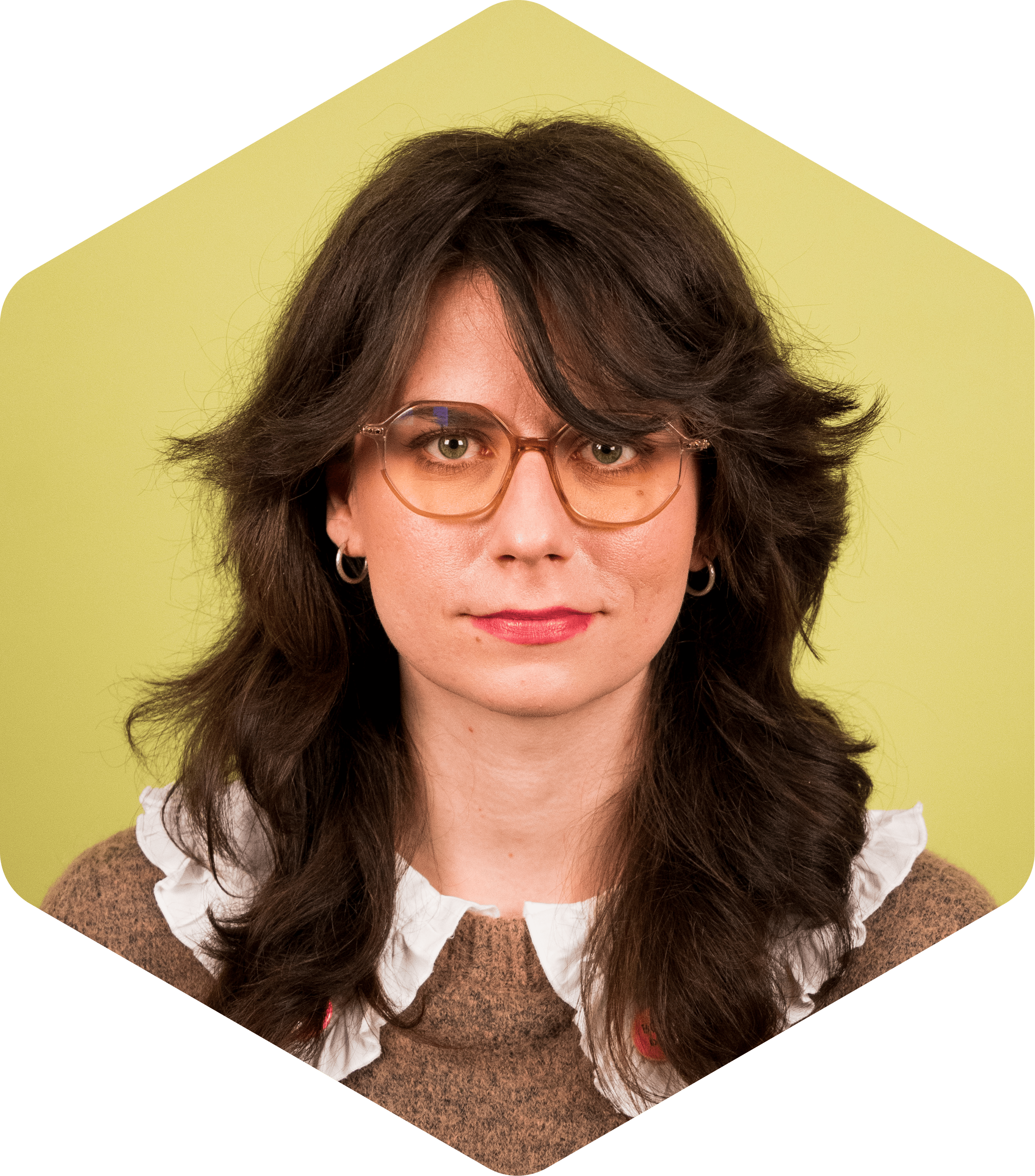 Kinga facing the camera, wearing glasses, on a light green background.