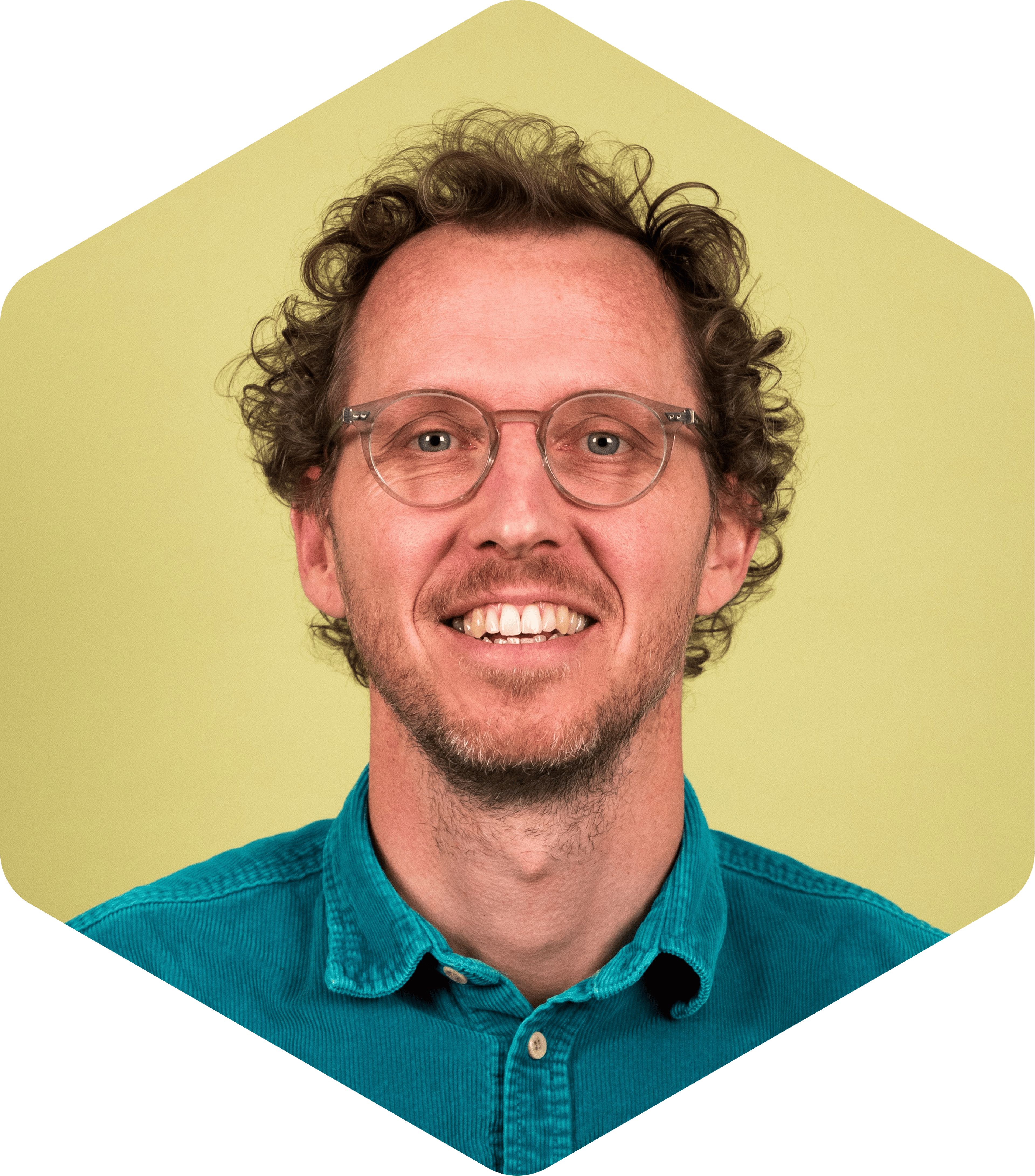 Sjoerd smiling, wearing a teal button-down shirt on a light green background.