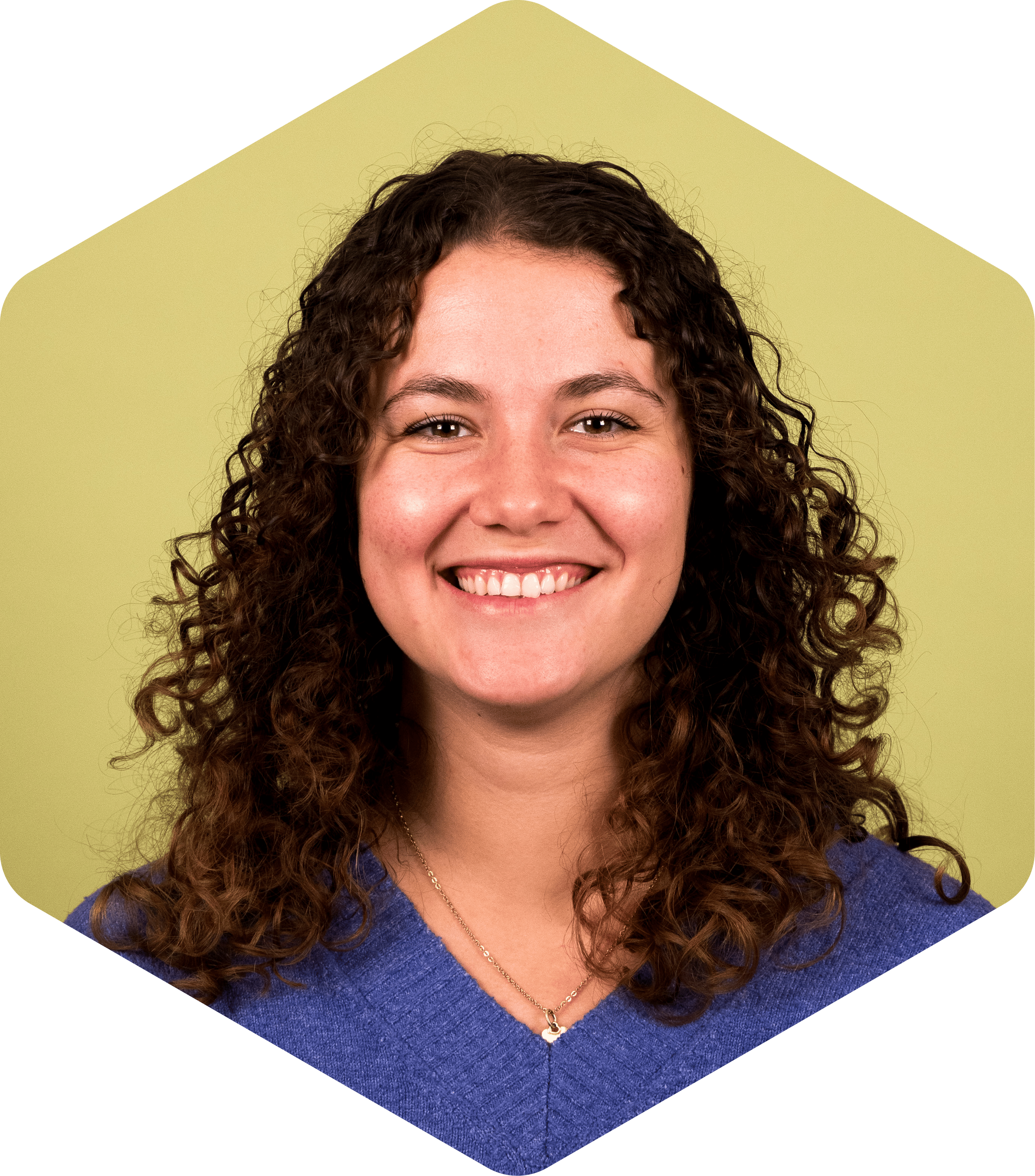 Portrait of Valeria smiling warmly at the camera against a light green background.