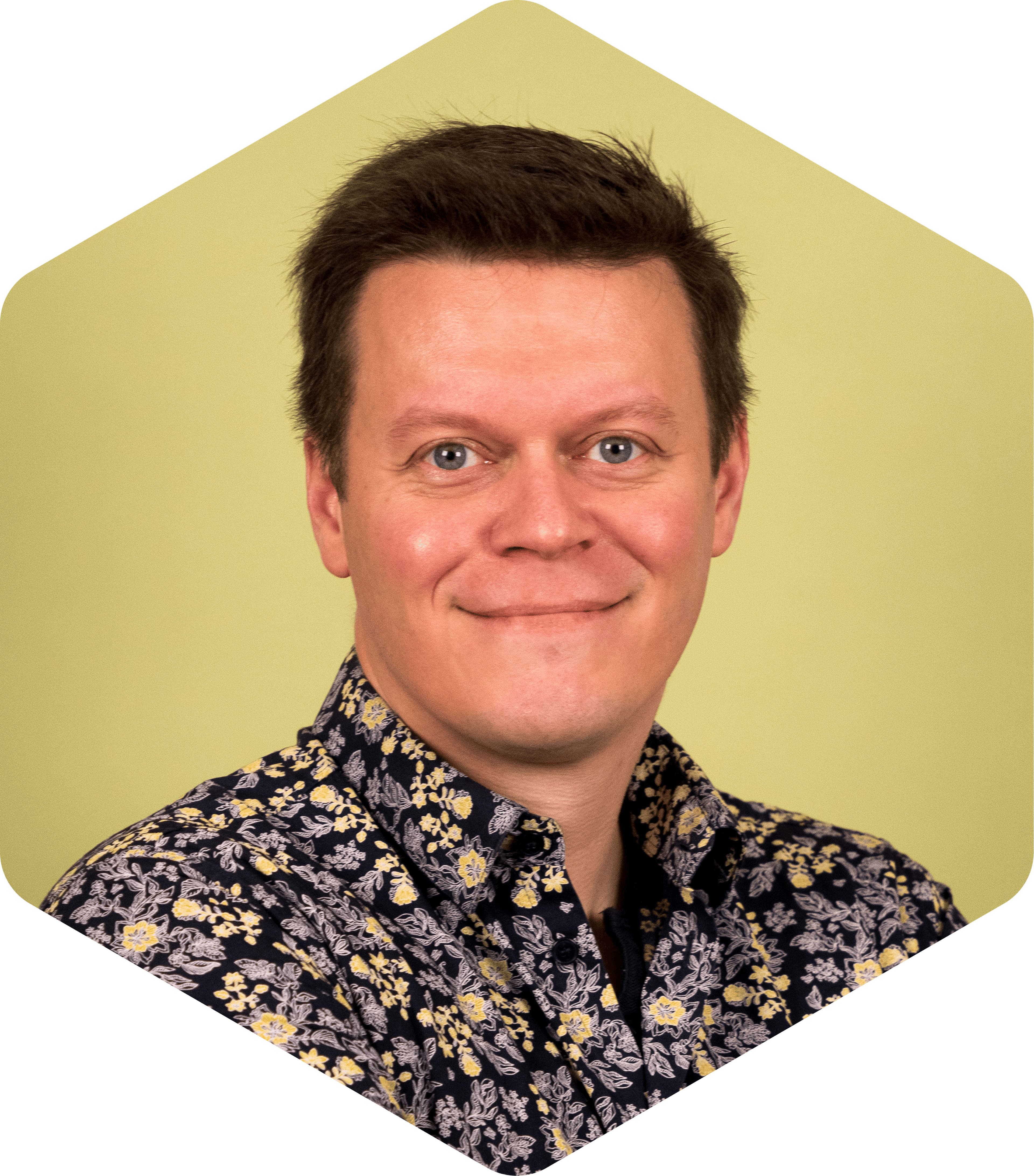 A headshot of Vesa on a green background, gently smiling at the camera. 