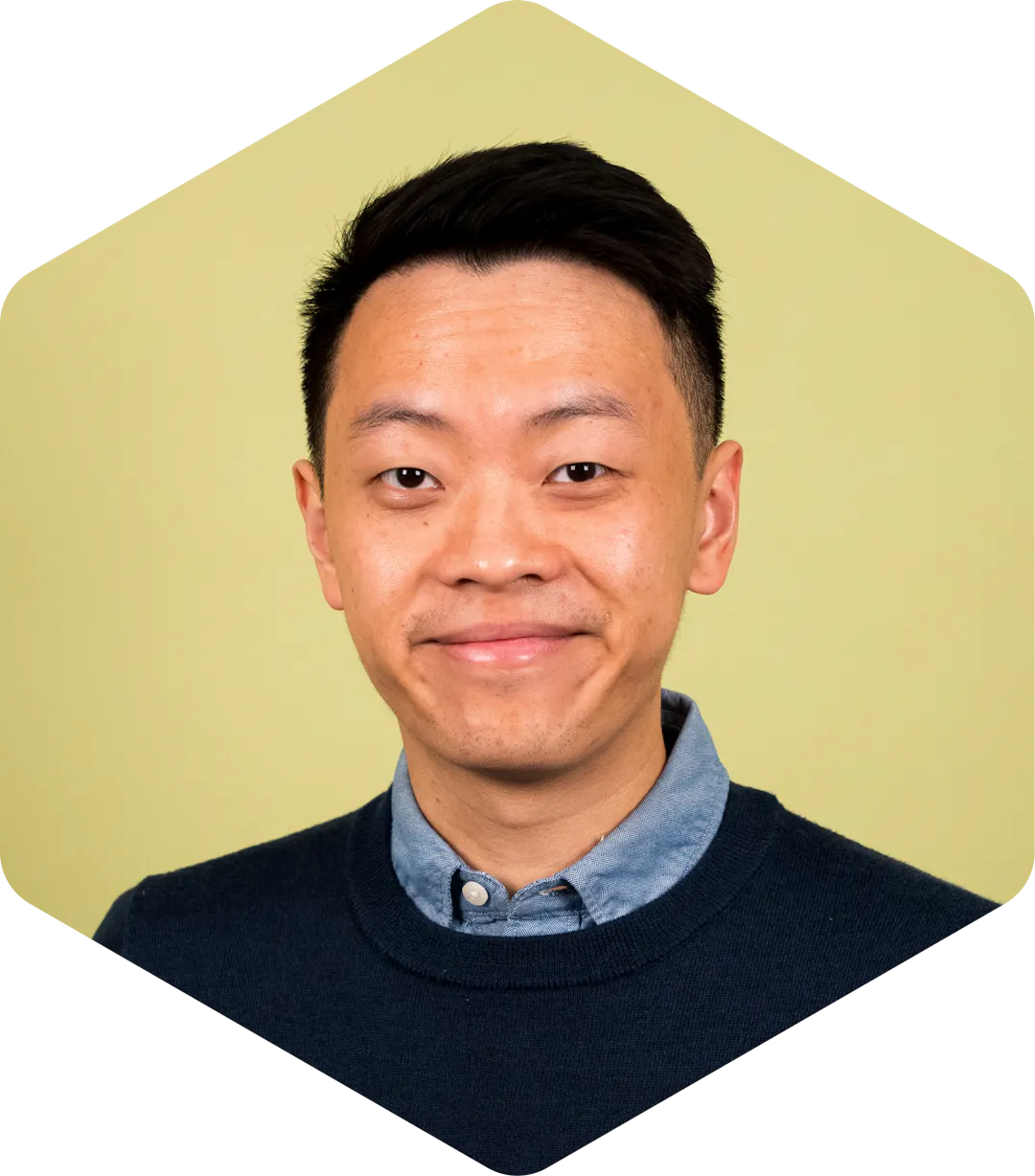 Portrait of Yifan on a green background, looking at the camera with a slight smile.
