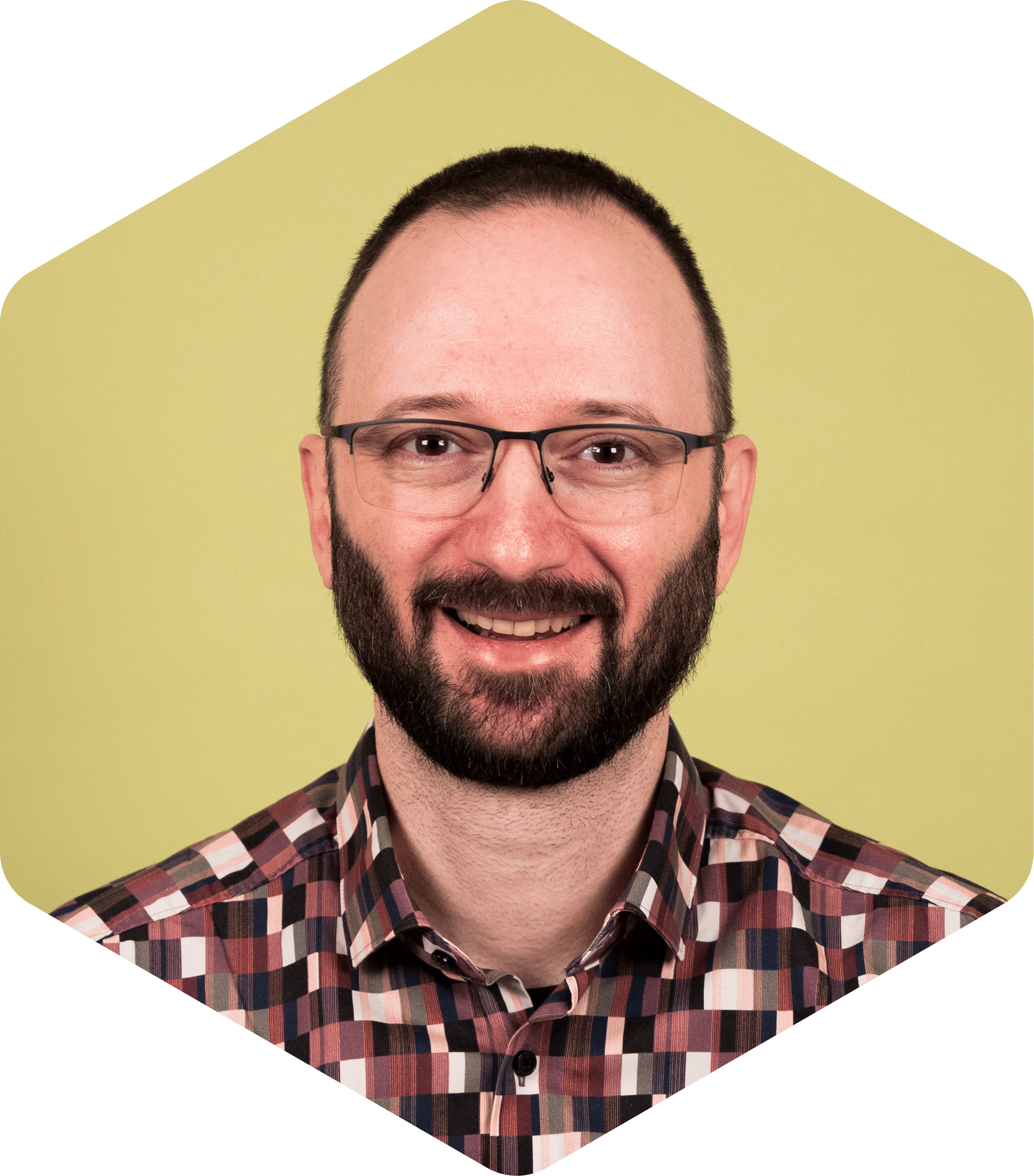 Boyan smiling, wearing a patterned shirt on a light green background.