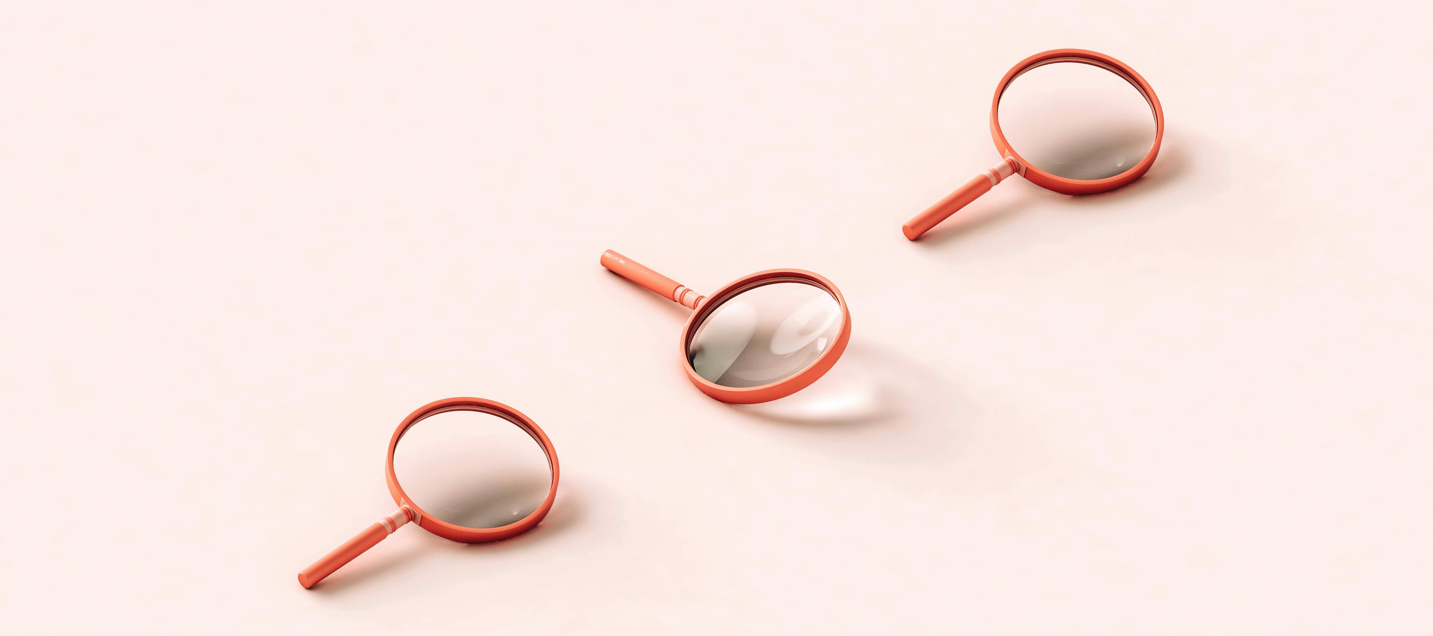 Three pink 3D magnifying glasses on light pink background.
