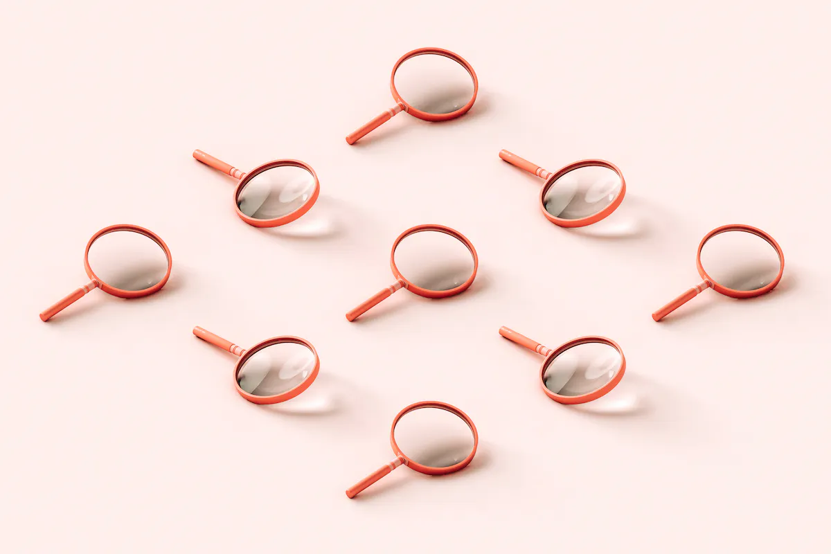 Nine pink 3D magnifying glasses arranged in a reclining diamond shape on pale pink background.