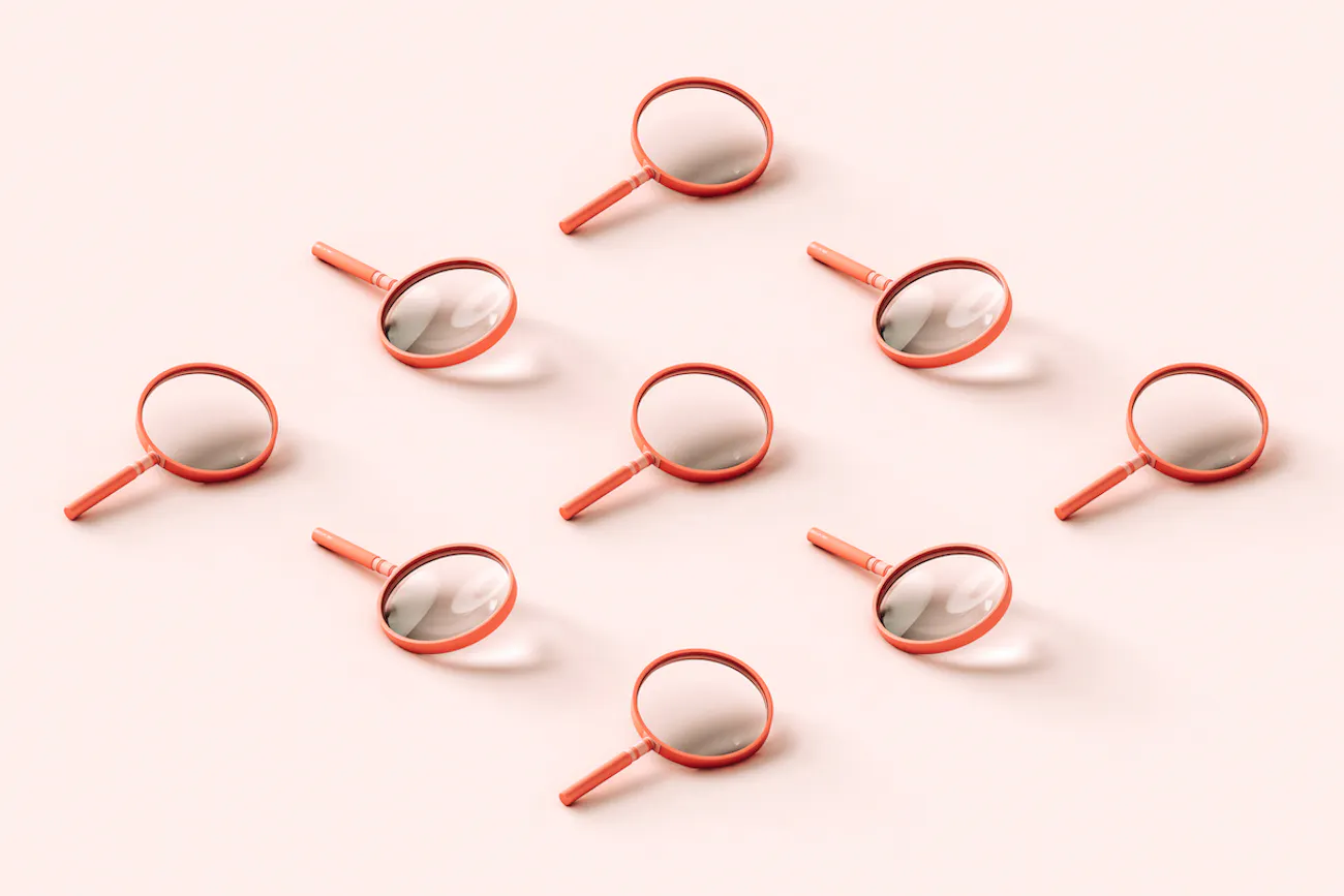 Nine pink 3D magnifying glasses arranged in a reclining diamond shape on pale pink background.