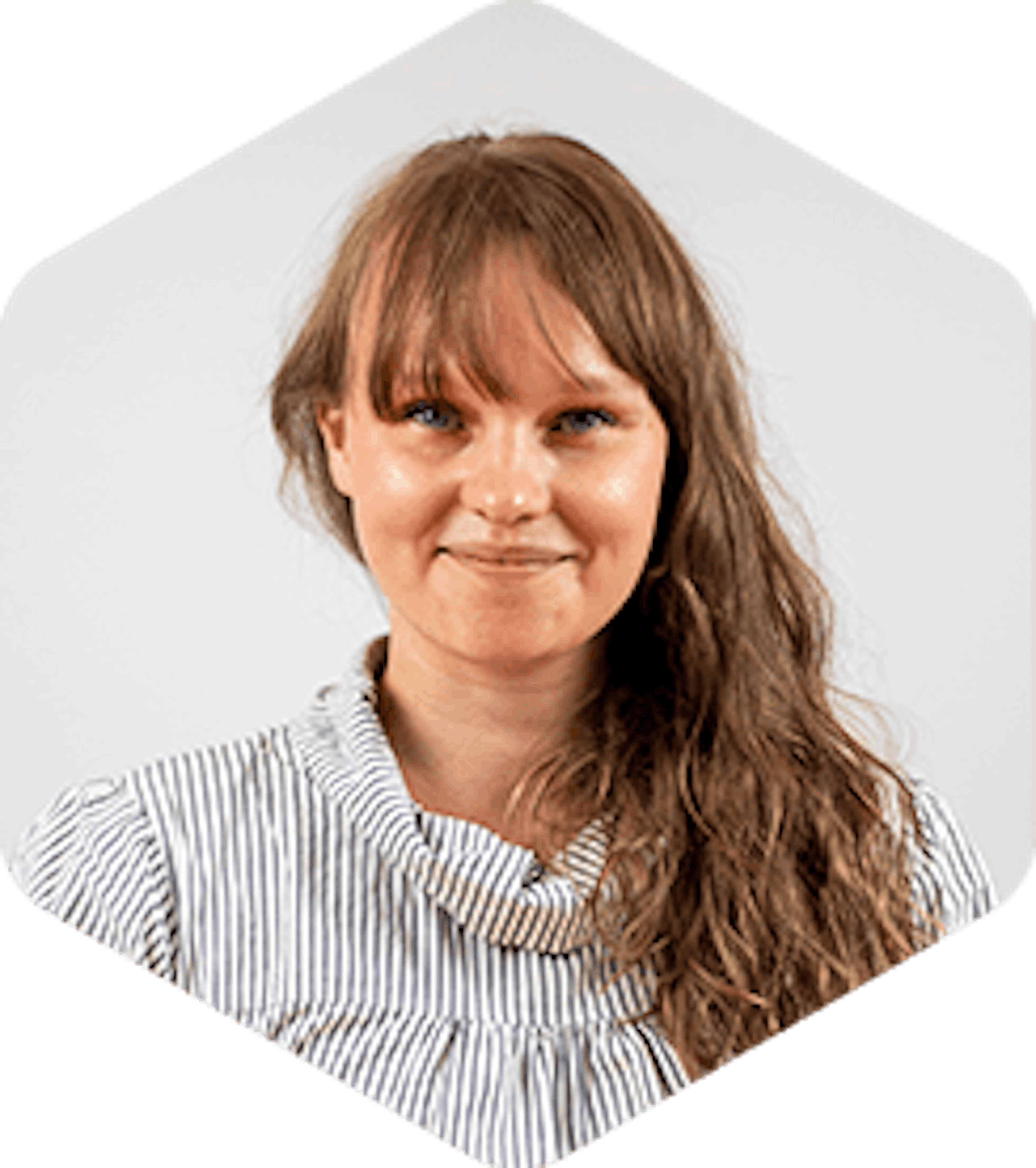 Sari has long light-brown hair and bangs and she's wearing a striped shirt with a slightly puffy collar. She's smiling at the camera.