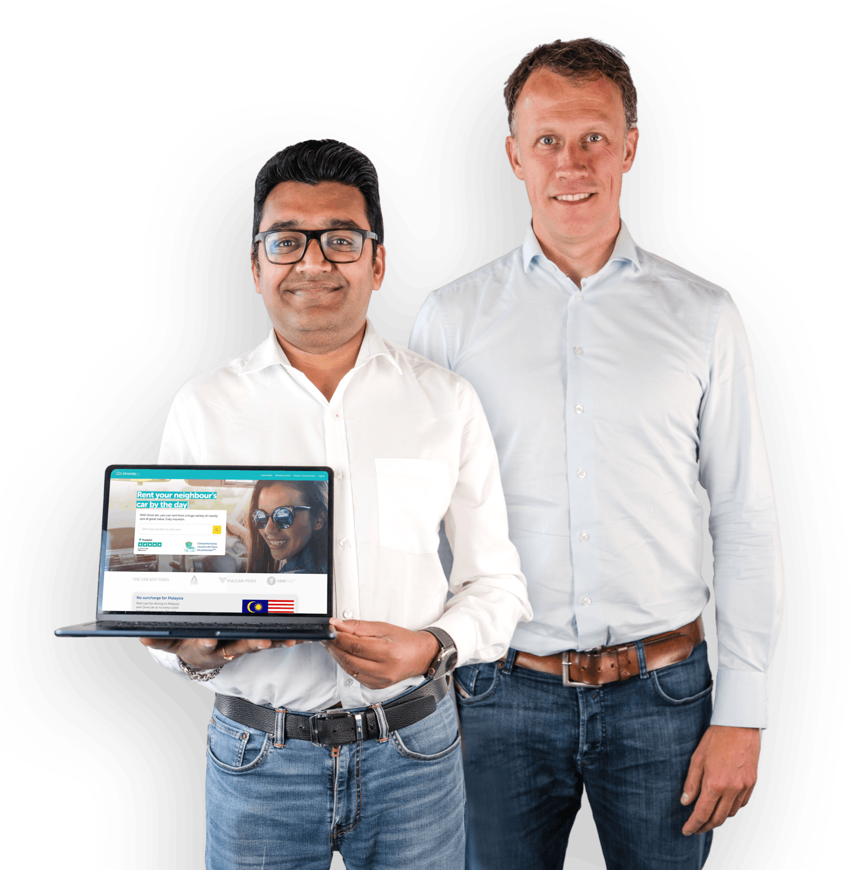Drive lah founders Gaurav Singhal and Dirk-Jan der Horst. Both founders are smiling and wearing light button-down shirts and jeans. Gaurav is holding a laptop that's open to the Drive lah home page.
