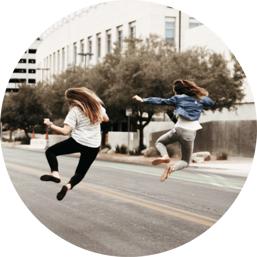 two women jumping in the street synchronously