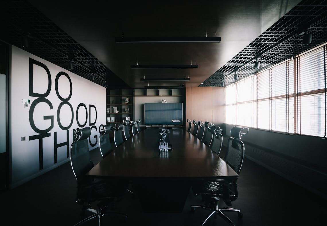 How Can Forex Risk Impact My Business? A Photo of a bit conference room with empty chairs and a mural that says "DO GOOD THINGS"
