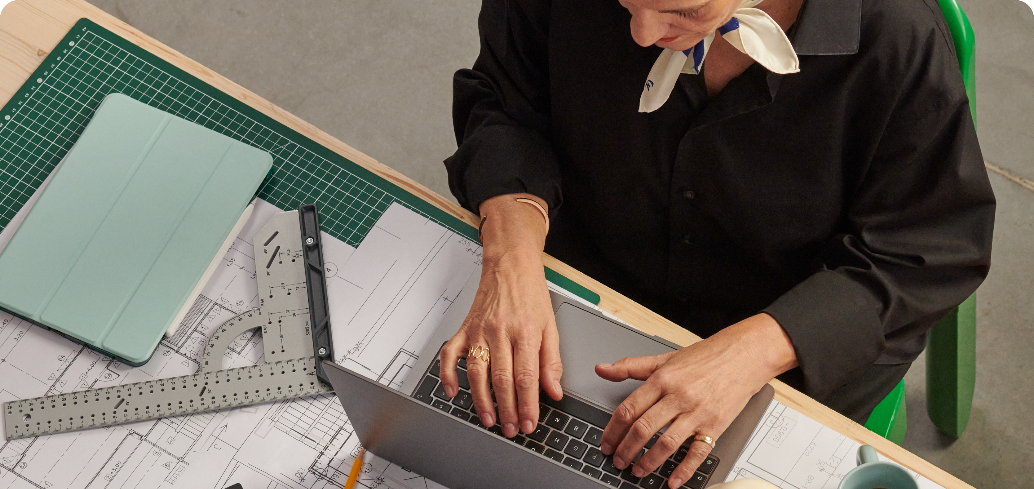 Une architecte consulte son compte depuis son ordinateur portable, assise à sa table de travail