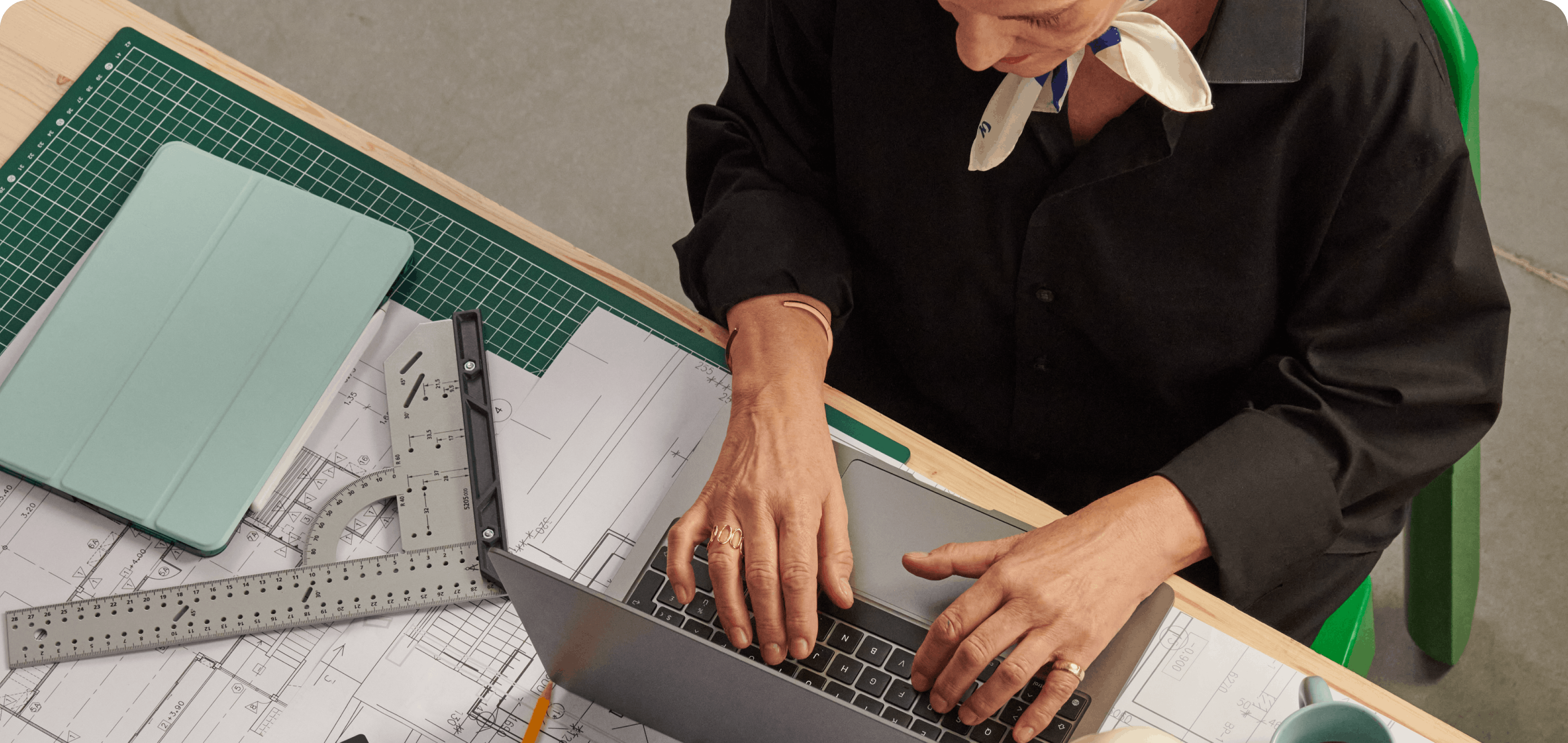 Une architecte consulte son compte depuis son ordinateur portable, assise à sa table de travail