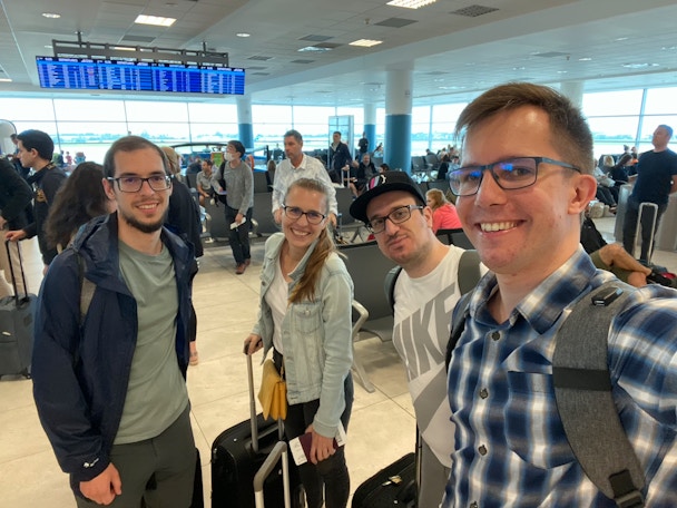 Martin, Aneta, Kostas, and Dawid, moments after reaching the flight gate and still in progress of catching breath.