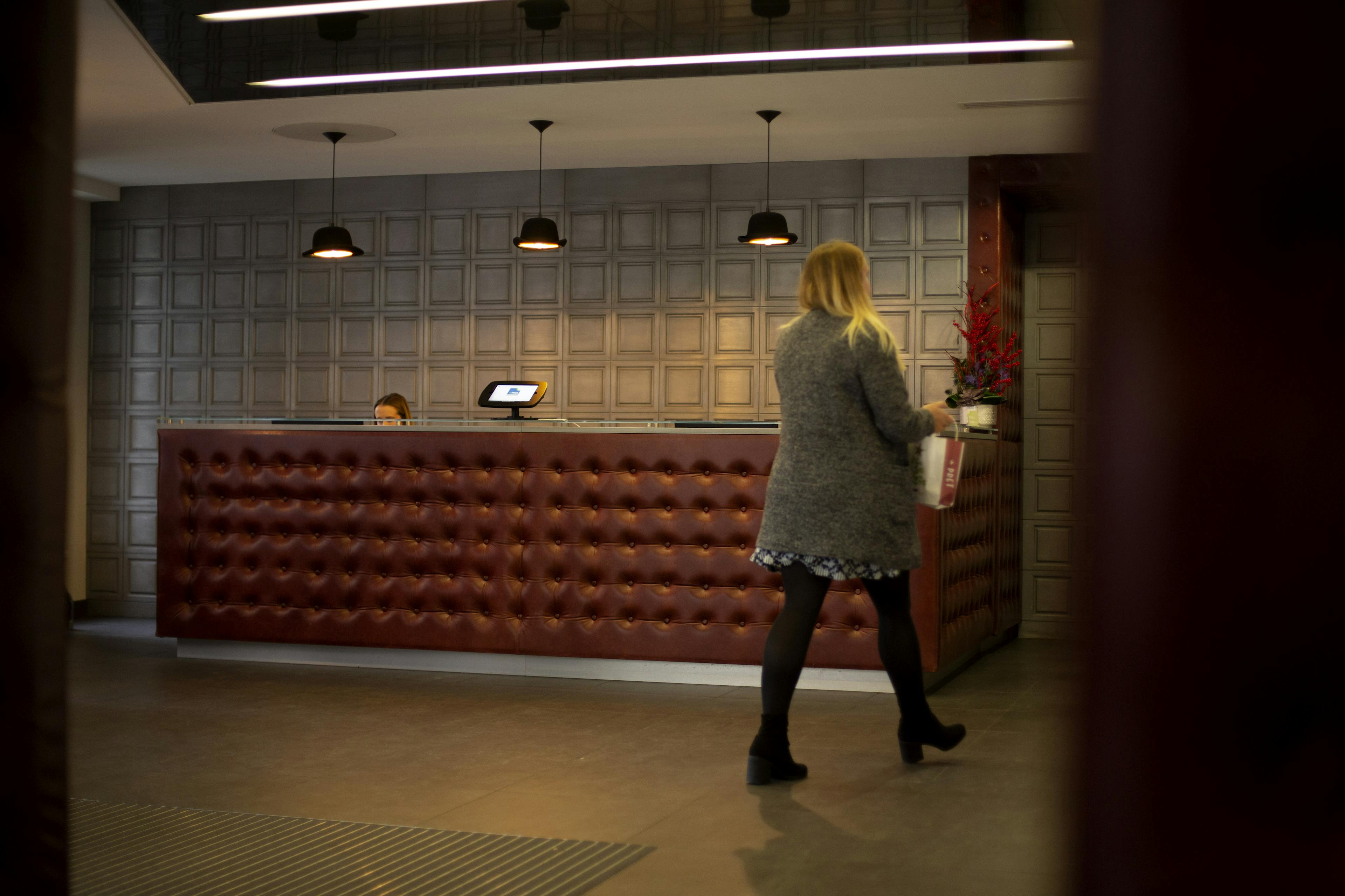 Image d'une réception ou d'un hall d'entrée avec un système de gestion des visiteurs sur la table d'accueil.