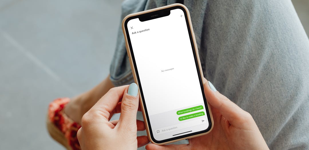 A photo with an over the shoulder view of a woman on her phone using the AI Assistant on Companion app