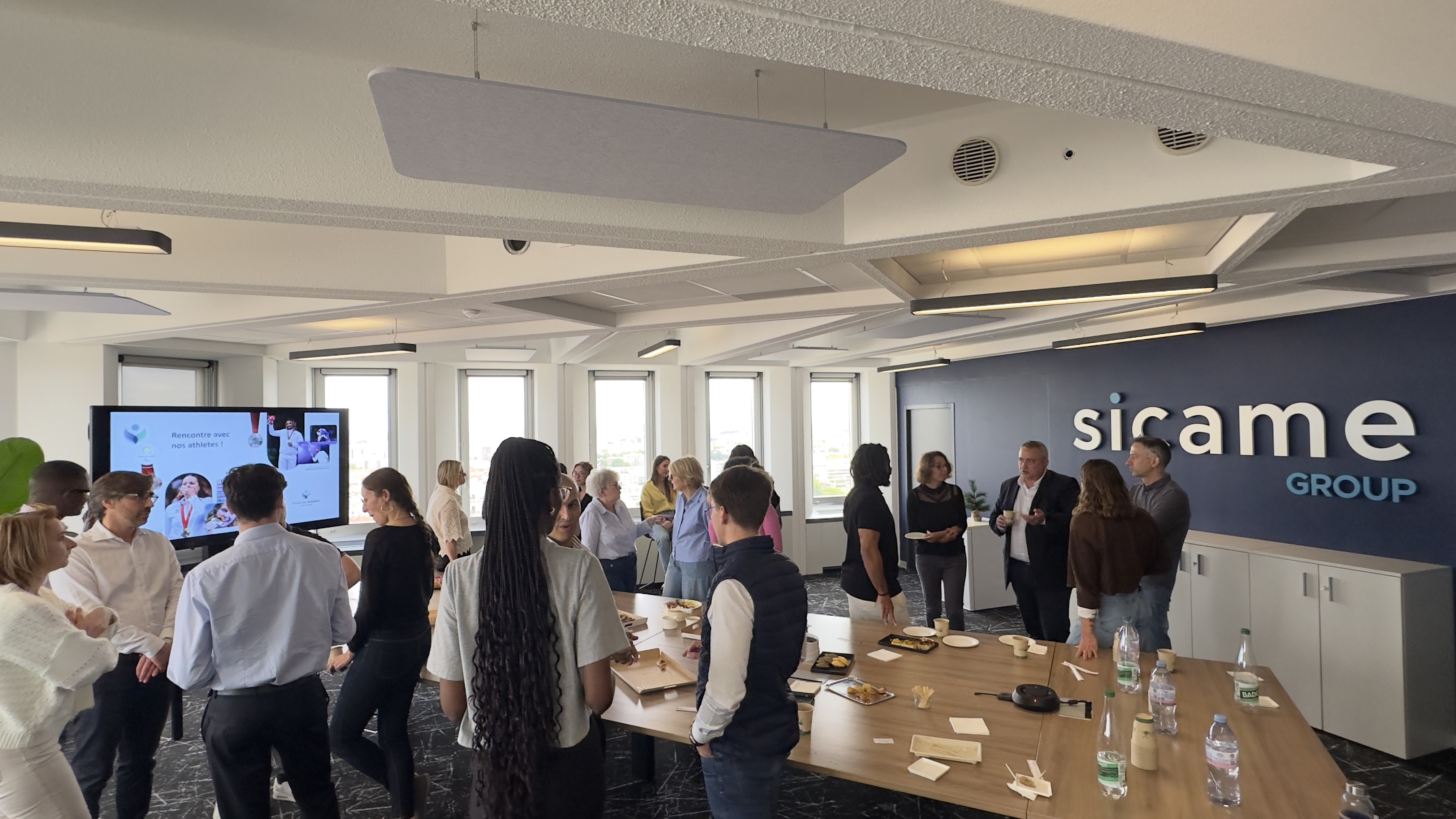 Des collaborateurs du Groupe Sicame et les deux athlètes discutant autour d'un table