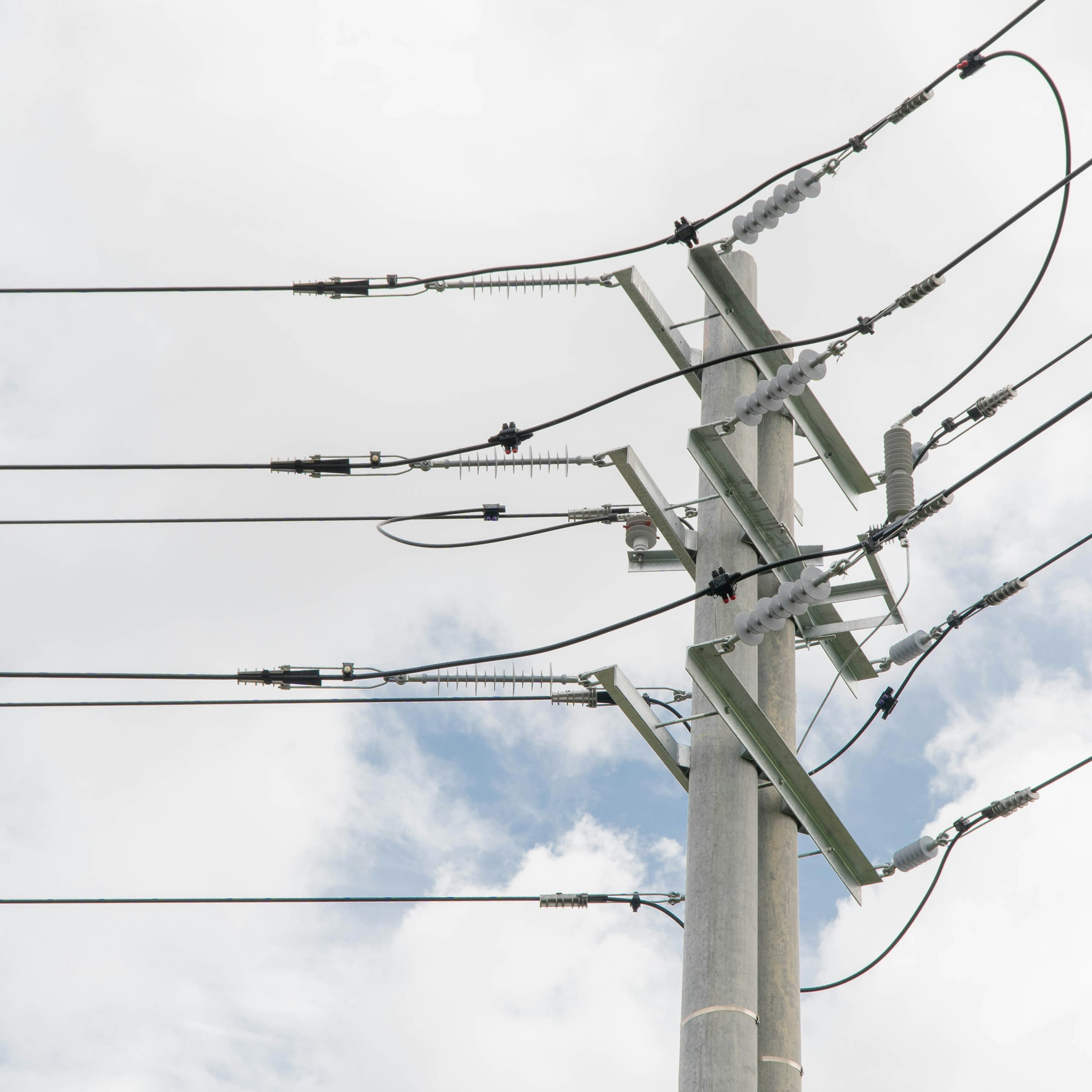 Poste de distribución eléctrica frente a un cielo nublado