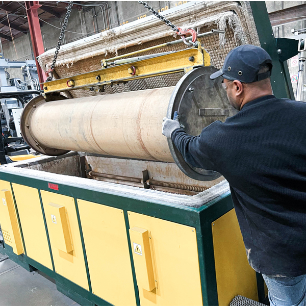 Technician positioning a roller in a machine for the armorgalv process