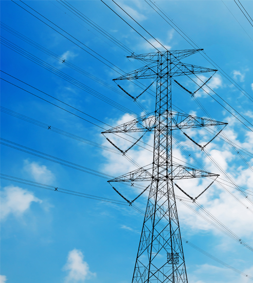 Transmission tower in front of a blue sky with clouds