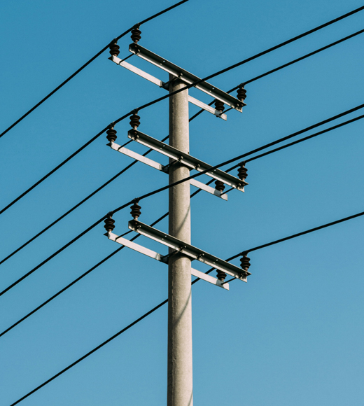 Electricity distribution pole in front of a blue sky