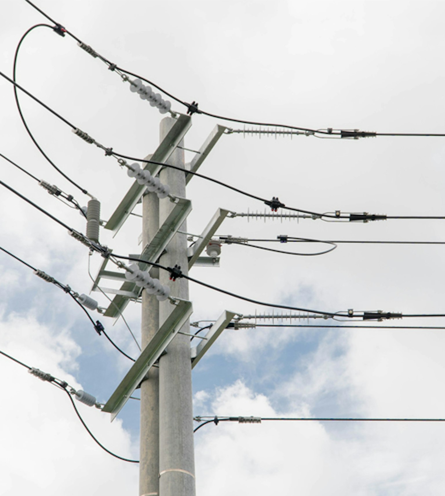Poteau de distribution électrique devant ciel nuageux