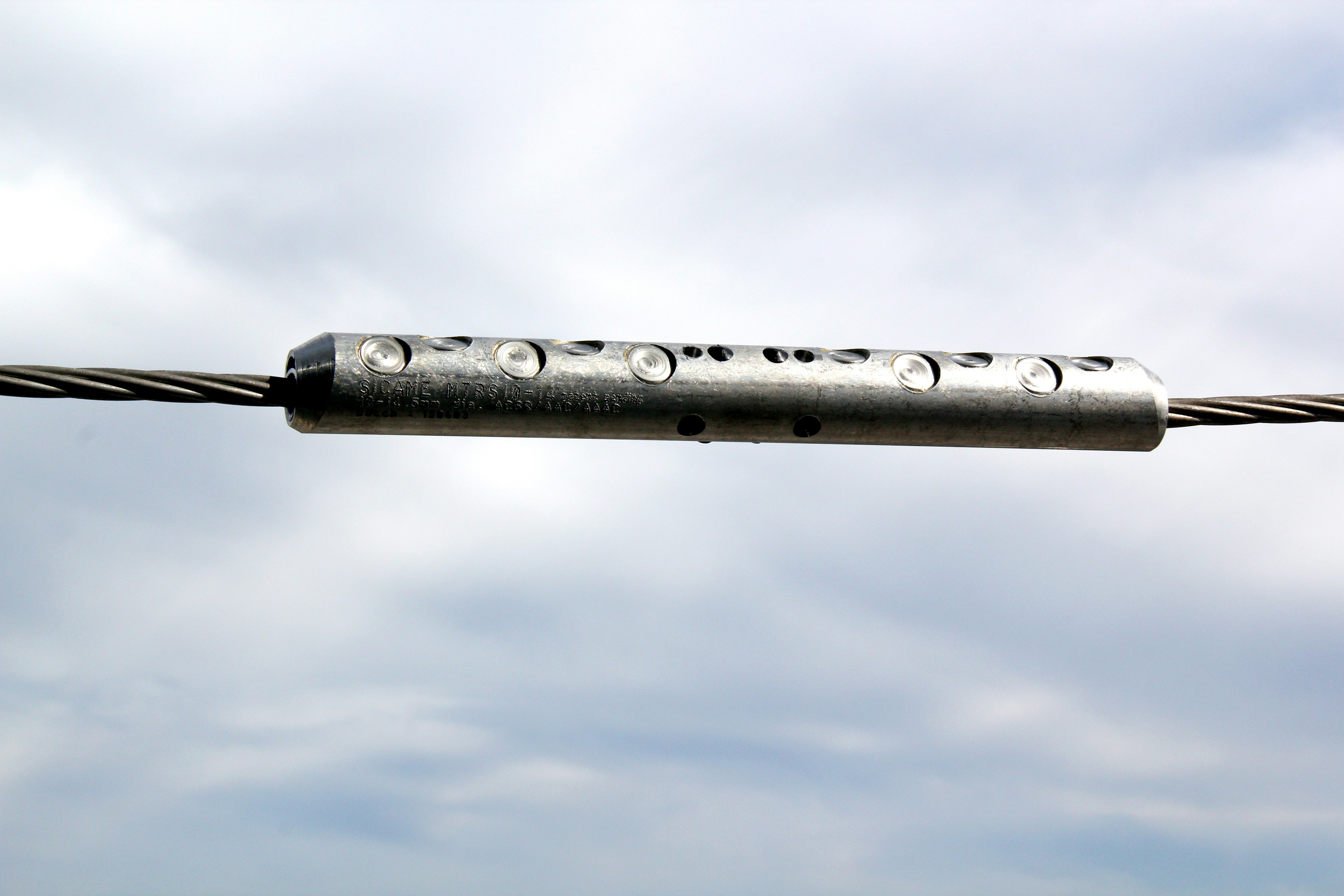 primer plano de la rodaja mecánica de reparación de tensión instalada en un cable