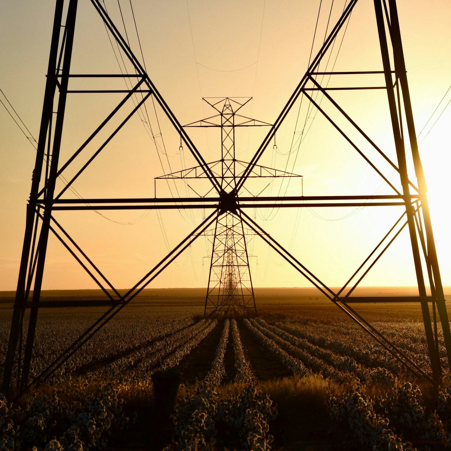 Torre de transmisión con el sol poniente al fondo