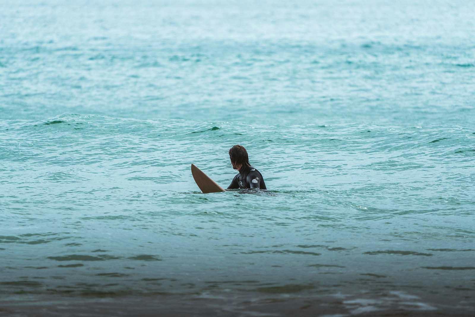 Surf em Portugal: Surfista no mar algarvio à espera de uma onda.