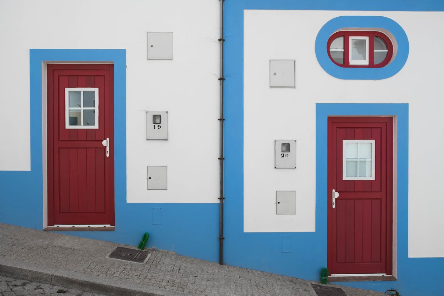 Bezaubernede weiße Häuser mit roten Türen und blauen Umrandungen an der Algarve.
