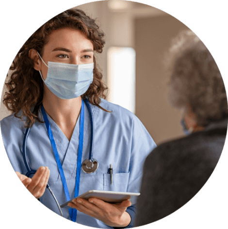 Female nurse, curly hair, speaking to patient 