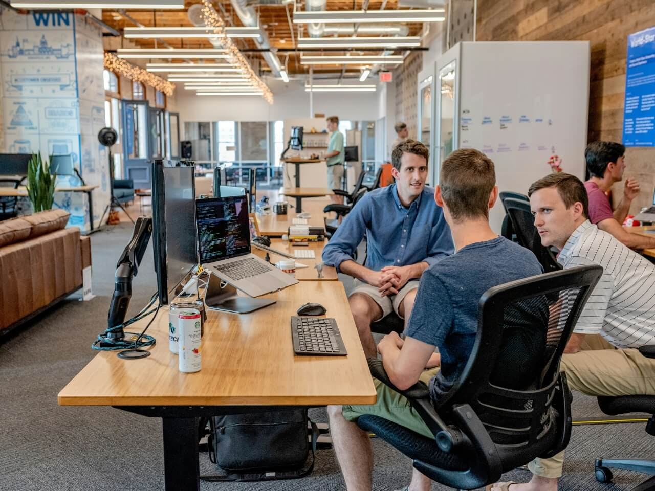 3 software developers seen discussing about their tech project, enjoying their their tech career in a flexible working environment