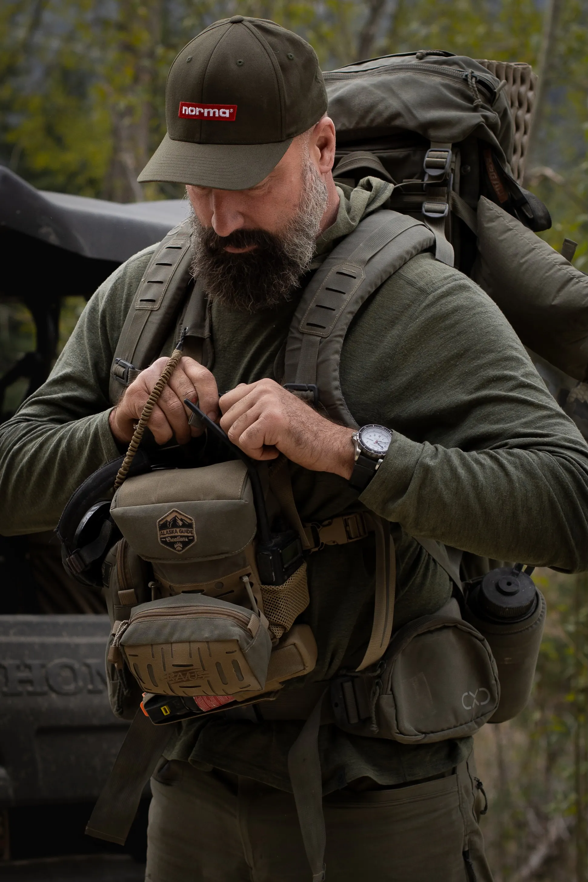 Travis Bader wearing a Marathon Watch 46 mm JDD and putting on a backpack