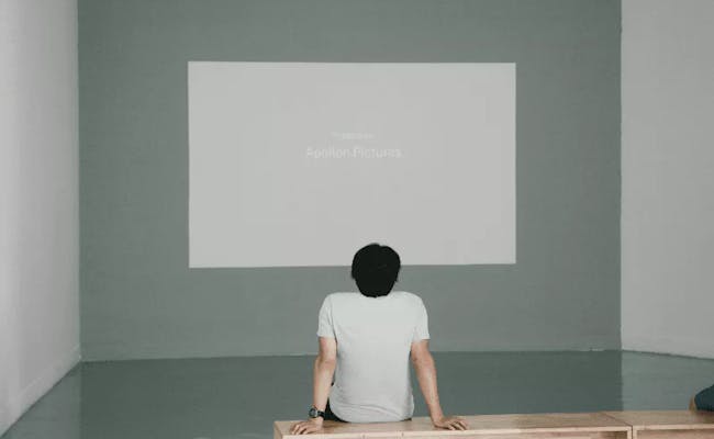 Man sitting with the back staring at a blank canvas